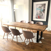 Tisch aus Altholz Eiche mit geschliffener Oberfläche auf zwei Rohstahlframes im Raum und vier Stühlen