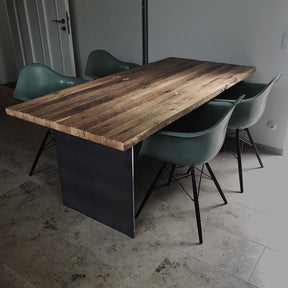 Tisch aus Altholz Eiche mit originaler Oberfläche auf zwei Rohstahlwangen im Raum mit vier Stühlen