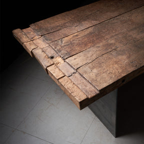 Tisch aus Altholz Eiche Balken mit originaler und gebürsteter Oberfläche und historischen Spuren auf Rohstahl-Wangen