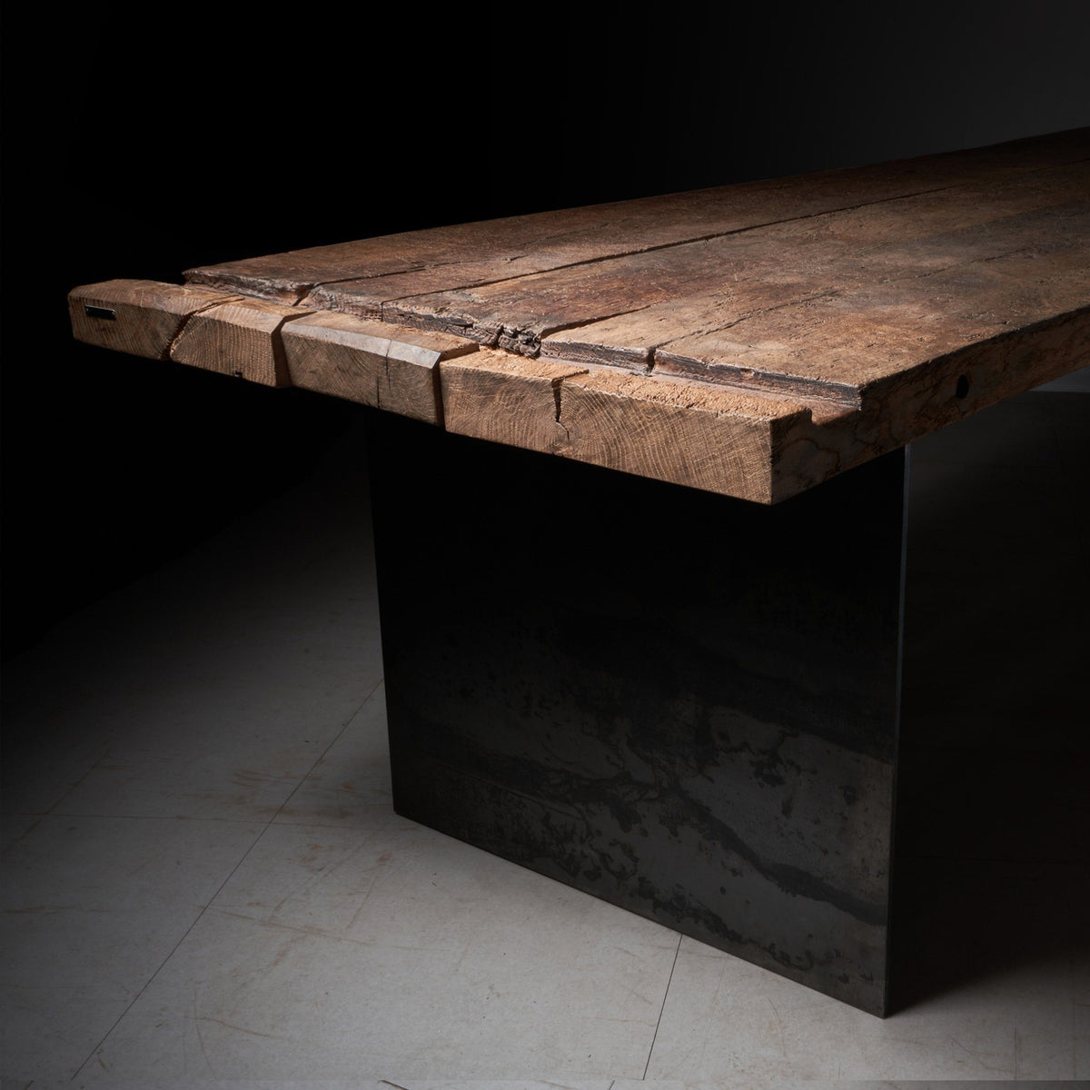 Tisch aus Altholz Eiche Balken mit originaler und gebürsteter Oberfläche und historischen Spuren auf Rohstahl-Wangen